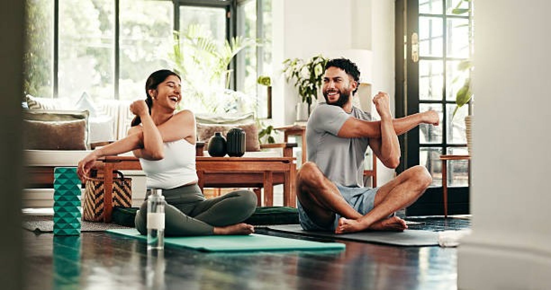 A peaceful young woman practicing mindfulness and yoga indoors with closed eyes, enjoying the calm atmosphere.